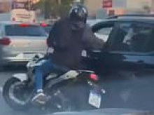 Instant karma! Moment motorcycle-borne robber trying to hijack car at gunpoint is forced to flee after driver snatches his weapon and turns the tables