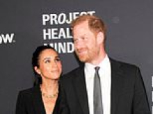 Harry and Meghan are named 'Humanitarians of the Year' after arriving hand-in-hand at glitzy award ceremony - hours after King Charles and Prince William put on a united front