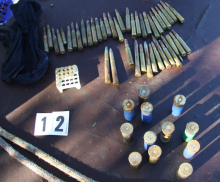 Hišne preiskave v romskem naselju: zaseženih več kosov nezakonitega orožja, tudi avtomatska puška