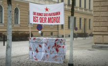 Transparent z napisom v nemščini Umetnost partizanov je umor! pred Koroškim muzejem v Celovcu