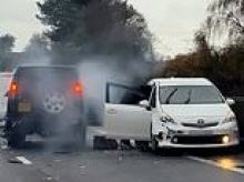 Terrifying moment hooded thugs are filmed 'robbing' driver in crashed Toyota Prius on motorway: Four men arrested