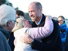 Prince William braves a chilly walk down memory lane on the beach in North Wales where he worked as an RAF pilot