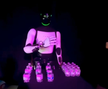 Robot Optimus pokaže svojo človeško plat in omedli, ko streže pijačo za Teslo