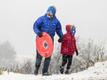 Families make the most of the snow as they grab their sledges for outdoor fun despite chilly conditions