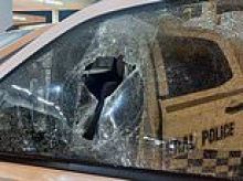 Bizarre rampage at Aussie airport involved passenger allegedly smashing cop car window with a rock before trying to flee on a shuttle bus