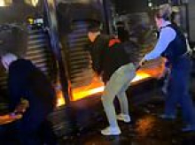 Moment hero passers-by smash their way into burning food shop to rescue man trapped inside as they break windows and prize open security shutter