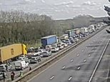 Two teens die after car plunges from bridge and crashes into minibus on motorway - as families spend hours trapped in traffic following road closure