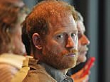 Prince Harry opens up about the 'real struggles' of fatherhood as he reveals he went to therapy as a new dad during emotional talk at AFL club - while Meghan is nowhere to be seen