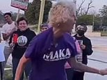 Gray-haired woman in 'Make America Kind Again' t-shirt filmed delightedly beating Donald Trump pinata to pulp with metal bar