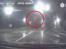 Moment pair of thugs throw 240-litre wheelie bin off bridge and onto moving police car - sending shards of glass 'flying' into officers