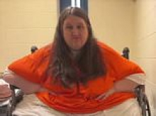 Obese stepmom who 'starved teen daughter to 35lbs' bulges out of wheelchair as she appears in prison cell to enter plea