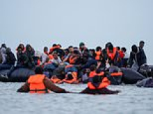 Britain's broken borders: Channel migrants board dinghies in front of smirking gendarmes while France suspends checks for UK holidaymakers to ease getaway chaos