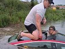 Incredible moment off-duty firefighter breaks woman free from car after she became totally submerged in water during terrifying flash flood