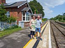 Couple raise their three children in £280,000 converted railway office with private level crossing - while trains stop outside of their bedroom up to 12 times a day