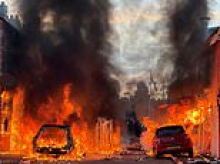 Belfast's night of fury over 'asylum seeker knife attack': Houses, cars and bus torched as ministers condemn 'thuggery' and Sudanese man, 30, is charged with attempted murder