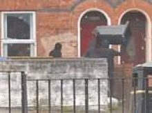 Moment masked thugs smash windows of Belfast house with wheelie bin in night of fury as rioters target migrants' homes after asylum seeker knife attack