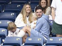 Declan Rice beams as he and partner Lauren Fryer hold a baby in the stands with their son Jude after England's draw with Ghana