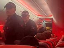 'Disruptive' plane passenger fights for life after being restrained onboard before police performed CPR on him in front of panicked flyers and sobbing aircrew