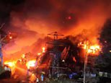 Huge inferno damages 140 cars at holiday parking site near Gatwick Airport as eight fire engines battled blaze: Man, 67, arrested on suspicion of arson
