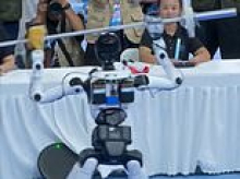Moment weightlifting robot collapses onto judges' table during Olympics... before being rushed onto a stretcher