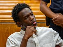 Male model struts out of court wearing $3,500 designer sneakers as he's charged with stealing $1m of clothing from upscale boutique