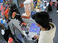 Moment balaclava-clad robber threatens shopkeeper with an eight-inch knife and demands money from till during terrifying late-night raid 
