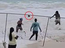 Wild moment 60-year-old woman is rescued from rough Bahamas surf after getting trapped by fence
