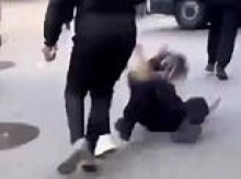 Policewoman is chased down the street, kicked to the ground and beaten by mob as riots rock France