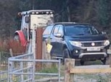 Moment feuding farmer solves his parking problem by picking up neighbour's truck with his tractor and carrying it 20 yards along lane