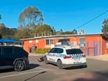 Shocking moment police car collides with teenage e-bike rider, sending him tumbling across bitumen