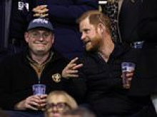 Prince Harry enjoys a beer in the stands at rugby match as he and Meghan settle back into life in the UK