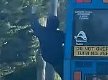 Shocking moment a daredevil teen risks his life by dangling out of a moving bus along one of Sydney's busiest roads