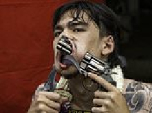 Feeling lucky, monk? Devotee shoves a handgun through his cheek as worshippers show devotion at Thai festival