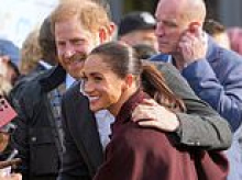 Harry puts a protective arm around Meghan as couple greet fans on first joint public appearance after return to UK 
