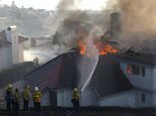 Brush fire threatens million dollar homes in southern California as high winds fan the flames