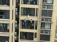 Moment three-year-old girl dangles from 12th-storey after climbing out window - with quick-thinking neighbours jumping into action
